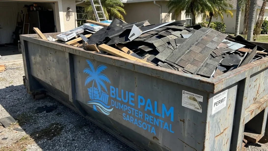 Hurricane and storm surge cleanup in Sarasota, Florida — container taking soaked drywall and roof debris
